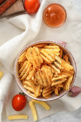 Bowl with tasty potato chips on table