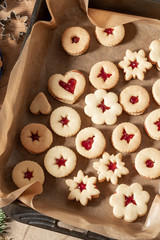 Linzer Christmas cookies filled with marmalade on parchment paper