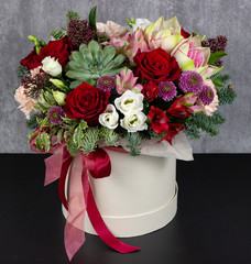 fresh arrangement of bright flowers in a hat box florist work place for text