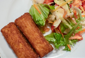 Potato croquette filled with cheese and herbs served with fresh green salad, tomatoes and pepper