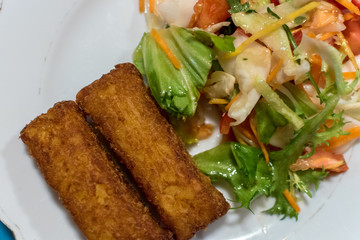 Potato croquette filled with cheese and herbs served with fresh green salad, tomatoes and pepper