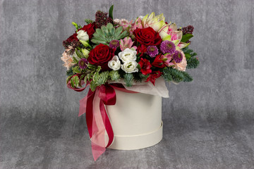 fresh arrangement of bright flowers in a hat box florist work place for text