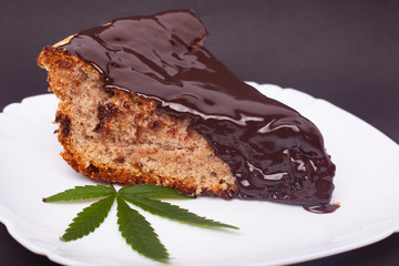 hot chocolate sponge cake with THC, cake with marijuana on a plate and green leaf