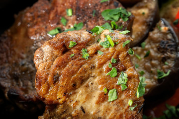 Macro shot of pork steak sprinkled with grated greens.