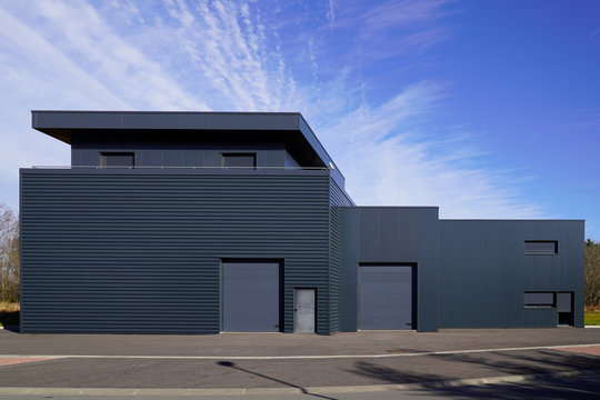 Gray Large Industrial Building Exterior Warehouse Grey Hangar Exterior With Rolling Gates In Blue Sky