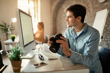 Smiling photographer using computer while working in a studio.