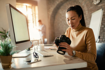 Asian female photographer working in a studio.