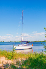 Yacht on a clear sunny day on the blue water of the river.