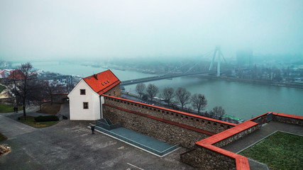 The Slovak National Uprising bridge over the river Danube in Bratislava, city in the fog. Slovakia. Copy space.