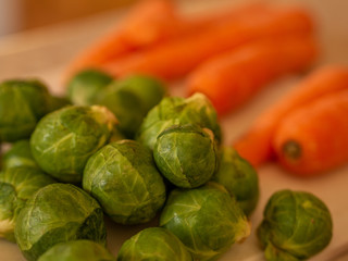 Brussels sprouts and carrots being prepared for a meal. Selective focus on sprouts in the foreground