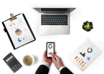 Businessman using smartphone and office desk top view