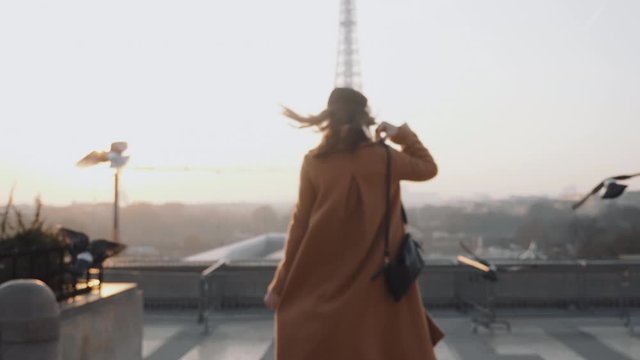 Rear view happy tourist woman running to misty sunrise Eiffel Tower view in Paris on romantic vacation trip slow motion.