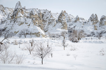 unique geological rock formations under snow in Cappadocia, Turkey.