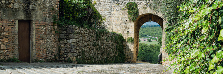 Fototapeta na wymiar Gate archway from old city in tuscany region, Italy, Monteriggioni. Wide banner