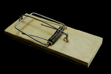 Wooden mousetrap without bait on a black background