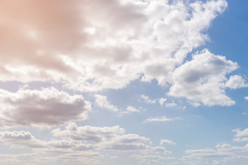 White cumulus clouds against the background against blue on a blue background.