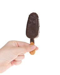 Female hand holding chocolate candy covered cake popsicle, isolated on white. Fun birthday party treats, easy to hold for small hands. Copy space