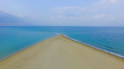 The end of the golden sandy beach and turquoise sea on the both sides 