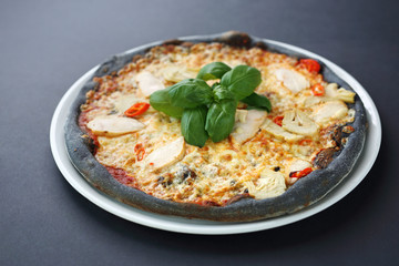 Black pizza, tasty pizza on black dough.