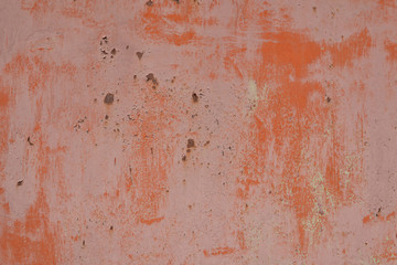 rusty metal wall with traces of old red and orange paint