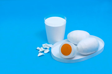 Paper eggs on plate and paper glass of milk