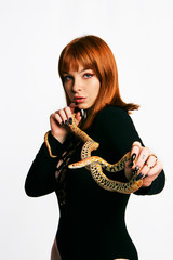 Beautiful woman in black bodywear and snake. Ginger model girl with fashion perfect make up.