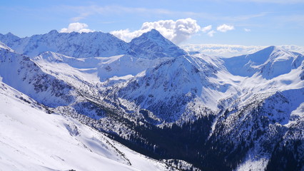 Panorama ze szczytu górskiego na zaśnieżone górskie szczyty - obrazy, fototapety, plakaty