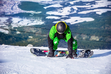 Fototapeta na wymiar A Young Man Snowboarder in the Winter Mountain 