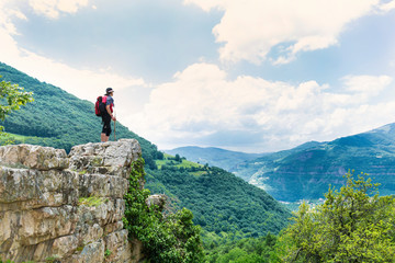 Naklejka premium Woman Standing on a Rocks in the High Mountain with Stunning Panoramic View