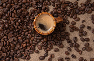 cup of coffee and beans on burlap with copy space for text.