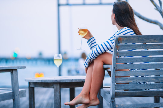 Young Girl With White Wine At Evening Outdoor Cafe.