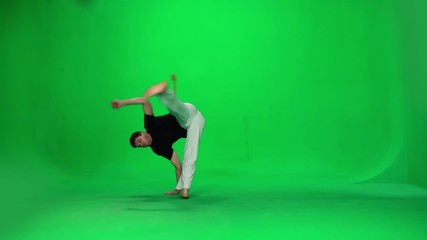 Man practicing capoeira on chroma key studio. Slow motion.