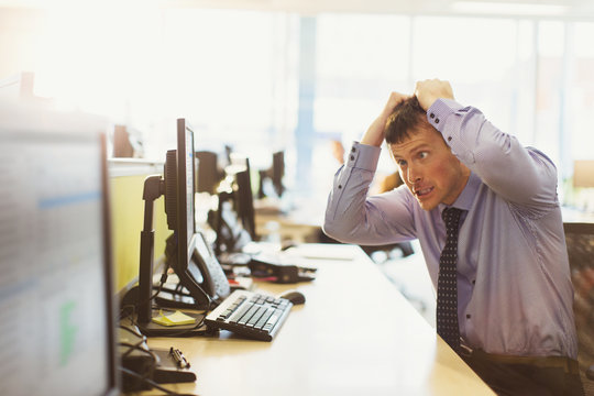 Stressed Businessman Pulling His Hair Out At Computer In Office