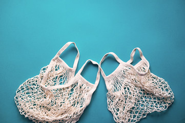 Fototapeta premium Replacing plastic bags. Taking care of the environment. Empty mesh, awosika on a blue background.