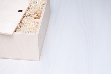 Wooden gift box with decorative straw or filler. Top view, copy space. Present.