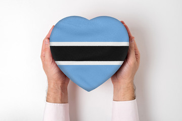 Flag of Botswana on a heart shaped box in a male hands. White background