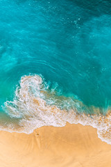 Beautiful sandy beach with turquoise sea, vertical view. Drone view of tropical turquoise ocean beach Nusa penida Bali Indonesia. Lonely sandy beach with beautiful waves. Beaches of Indonesia.