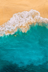Fototapeta na wymiar Beautiful sandy beach with turquoise sea, vertical view. Drone view of tropical turquoise ocean beach Nusa penida Bali Indonesia. Lonely sandy beach with beautiful waves. Beaches of Indonesia.