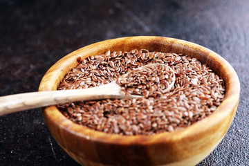 Uncooked linseed in wooden spoon, rustic style. Healthy linseed