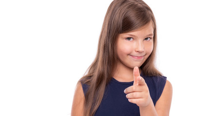Little girl points her finger at you isolated on white background.