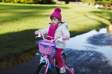 toddler girl ridding bicycle in winter countryside park, Northern Ireland