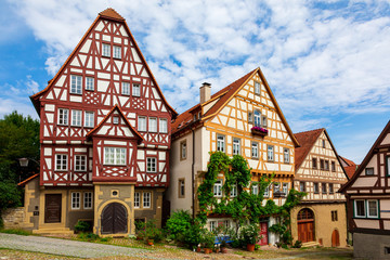 Fototapeta na wymiar Historic, medieval half-timbered houses. The old German city of Bad Wimpfen in Baden-Württemberg, Germany. Summer photo on a sunny day against a bright blue sky