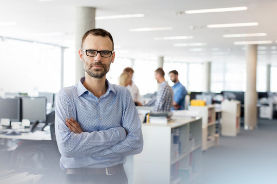 Portrait Serious Businessman With Arms Crossed In Office