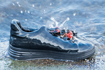 A Spots Shoe Covered by Glazed Ice and Constantly Watered by the Waves from the Lake in Mid-Winter