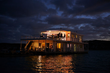 Summer houseboat illuminated on night ocean