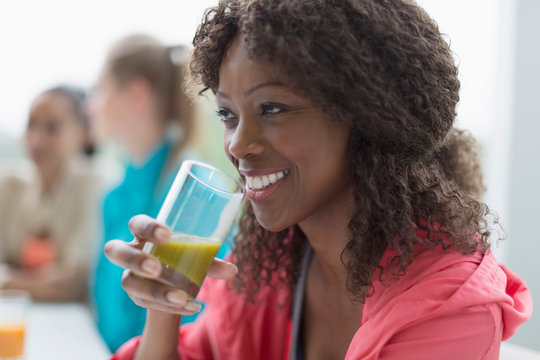 Smiling Woman Drinking Healthy Green Smoothie In Cafe Post Workout