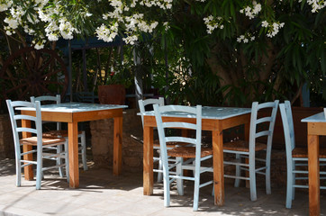 Fototapeta na wymiar Wooden table and blue chairs on terrace in restaurant. Patio restaurant with empty sitting place.