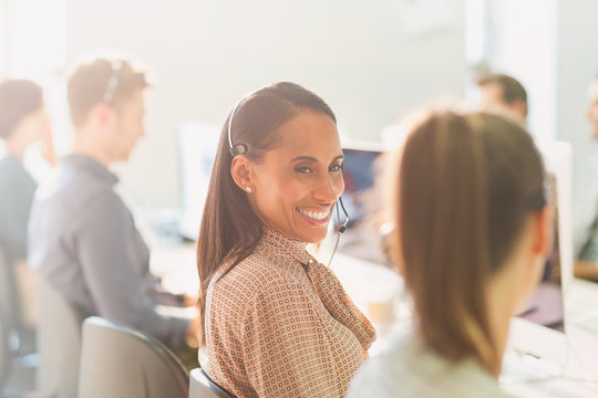 Smiling Female Telemarketers Wearing Headsets Talking In Sunny Office