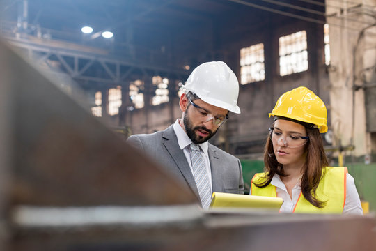 Manager and female steel worker meeting in factory