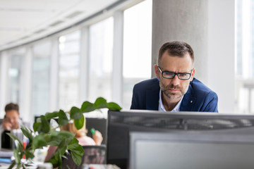Serious businessman working at computer in office